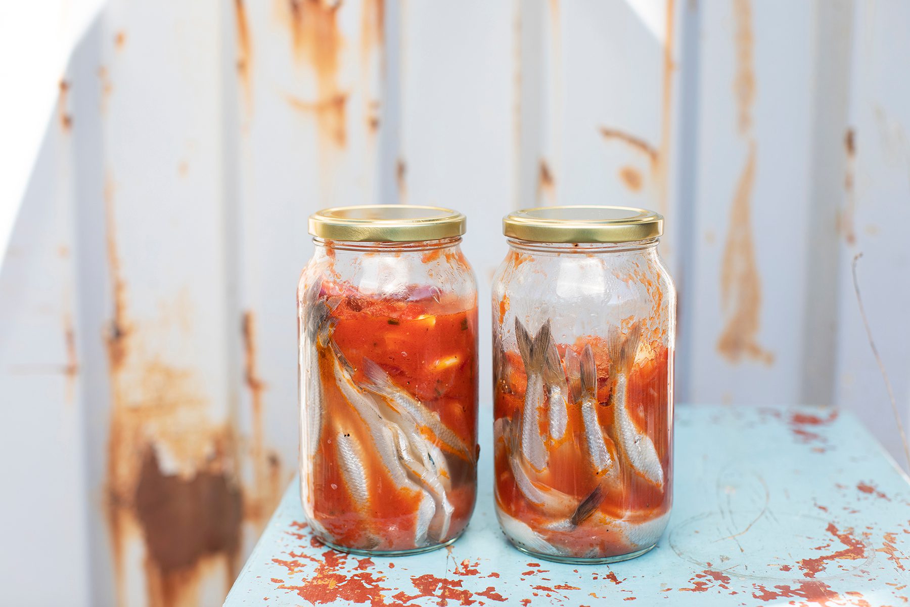 Två glasburkar med inlagd nors i tomatsås står på ett bord